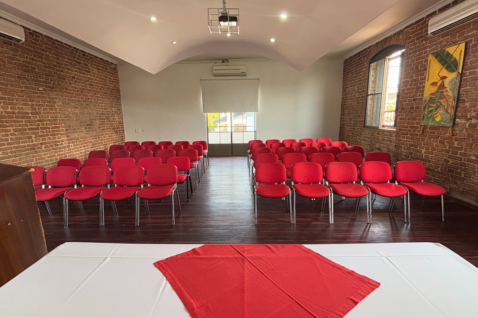 Sala de eventos con sillas rojas en Hotel Los Puentes Comfacundi, ideal para congresos.