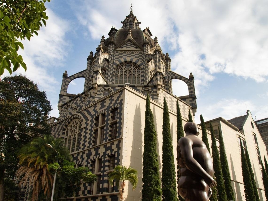 Art Deco hotel facade with statue & trees. Hotels in Medellin | Tequendama Hotels | Official Web