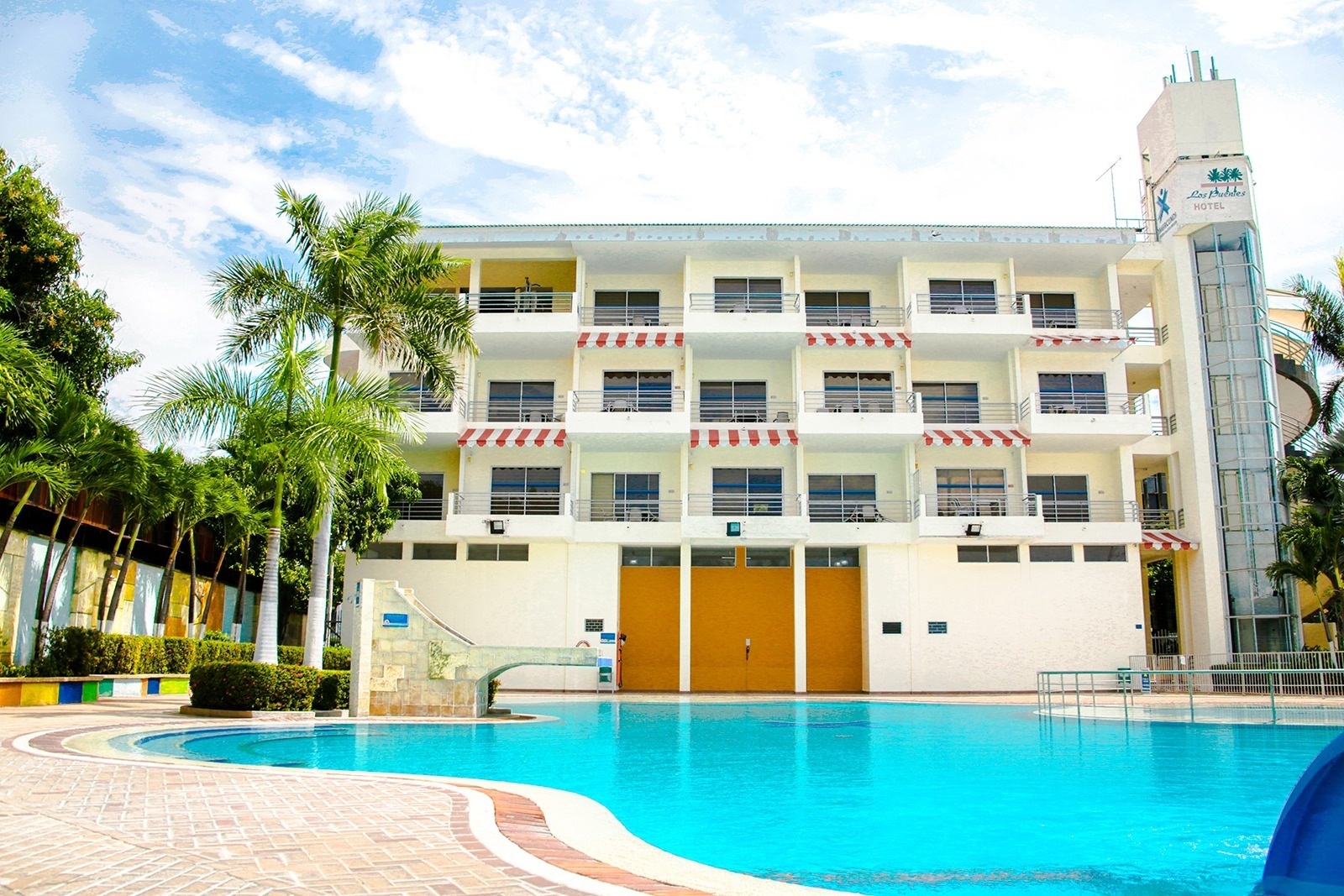 Hotel Los Puentes Comfacundi | Girardot hotel with pools and palm trees.