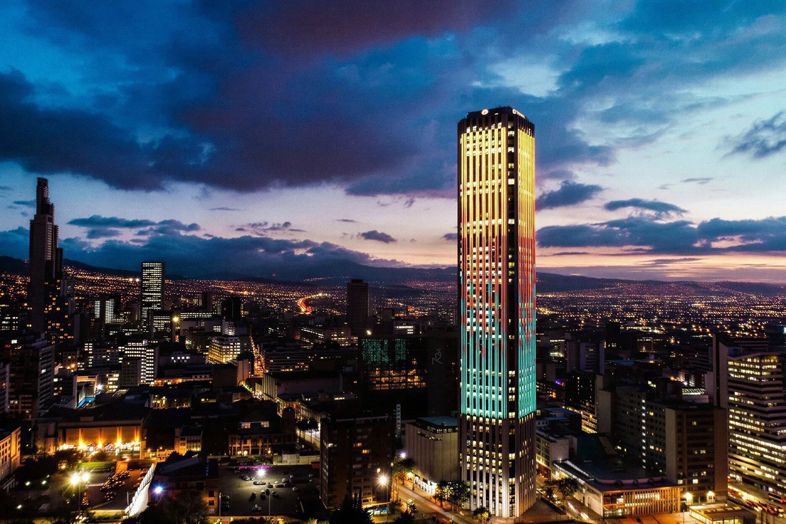 Skyline of Bogota at dusk, featuring a brightly lit skyscraper. Hotels in Bogota | Tequendama Hotels | Official Web
