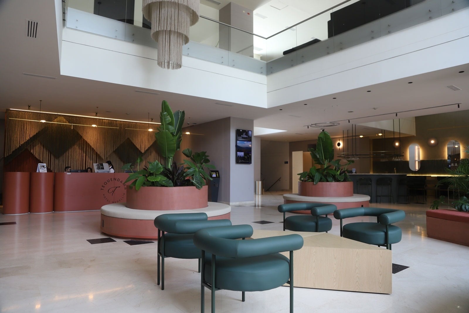 Tequendama Hotel Medellín | Modern lobby with lush plants and chic seating, part of our design hotel with rooftop jacuzzi.