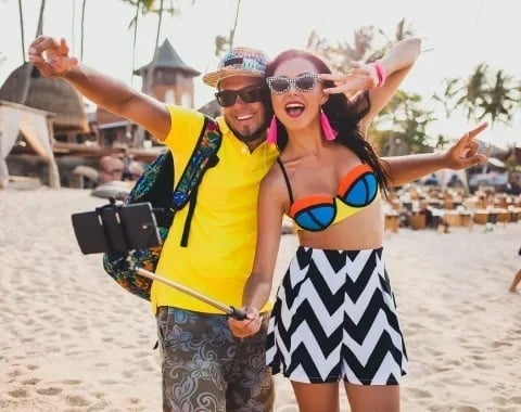 Pareja feliz en Tequendama: Corporativa haciendo selfie en la playa.