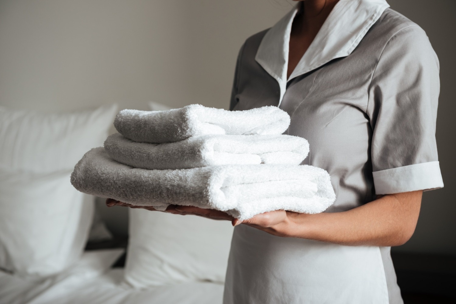 Tequendama Corporativa: Mucama con toallas blancas en habitación de hotel.