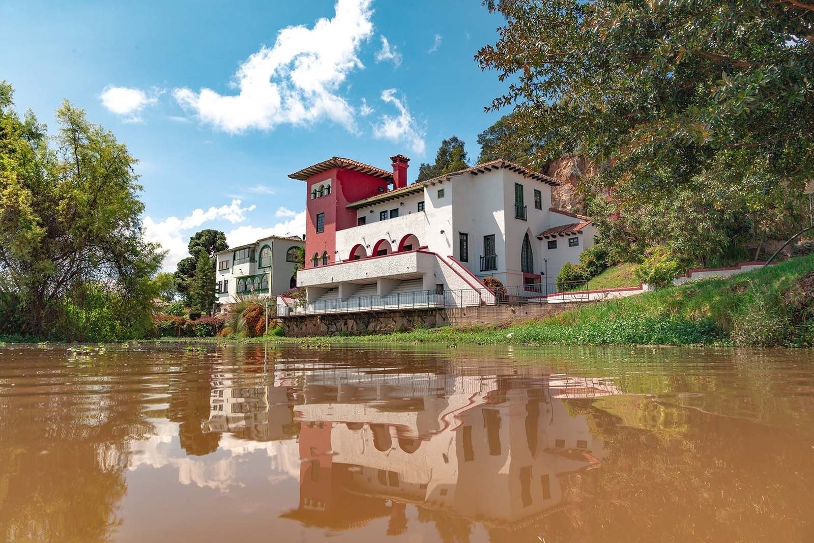 Hotel Refugio El Santuario: Fachada blanca y roja, reflejo en laguna de Fúquene.