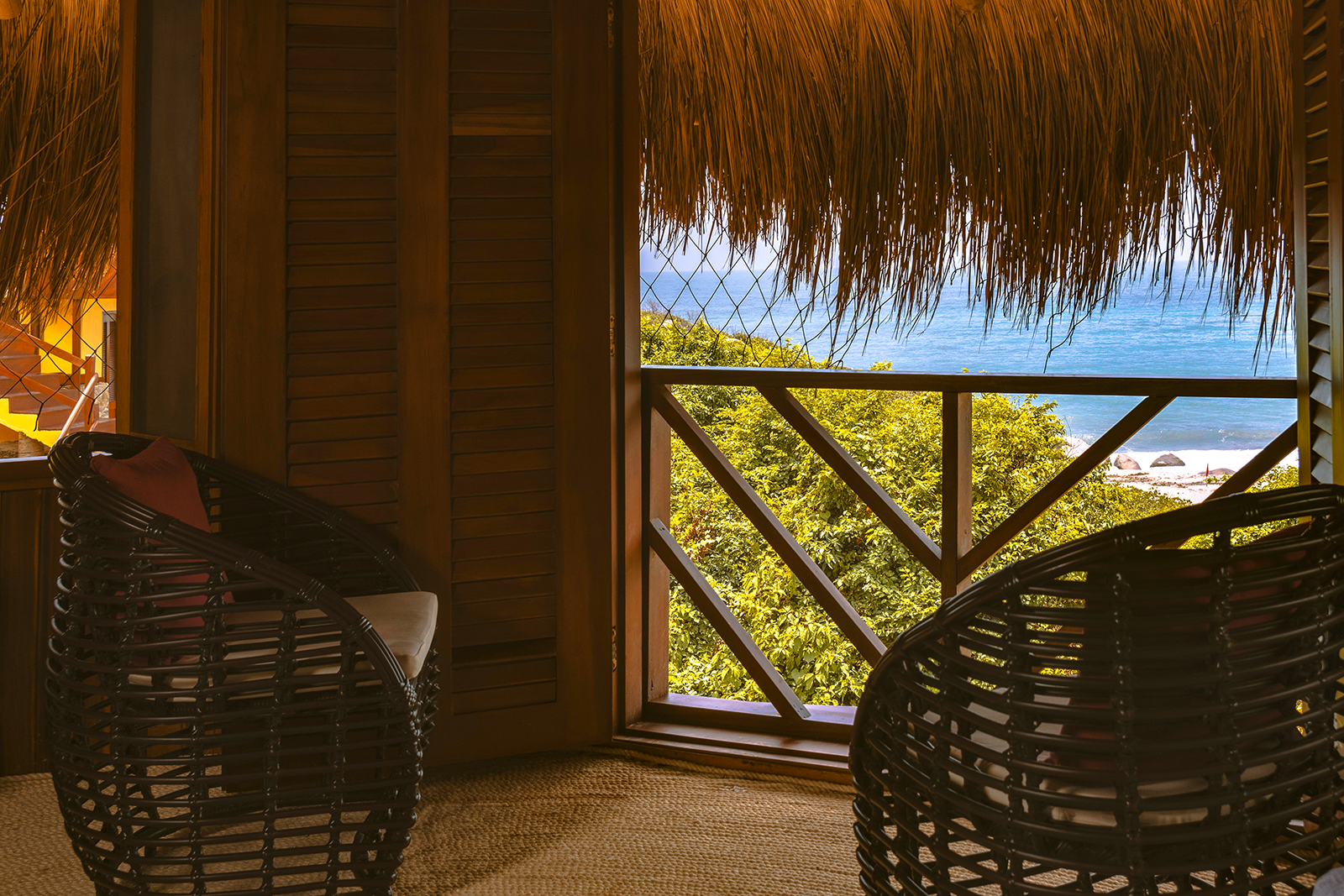 Cozy chairs on balcony with ocean view at Ecohabs Tequendama, Tayrona Park.