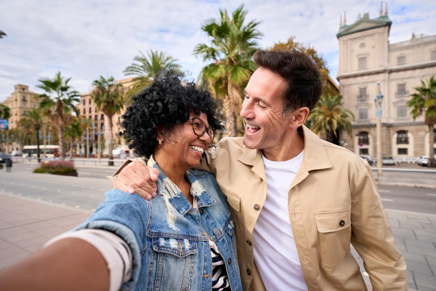 Pareja sonriente selfie Tequendama: Corporativa vista urbana, palmeras y arquitectura.