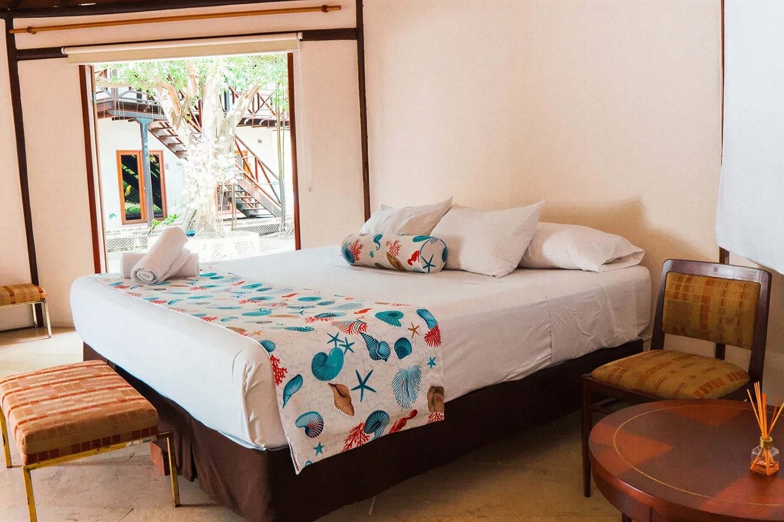 Hotel Rosario de Mar: Cozy room with beach-themed decor and large window view.