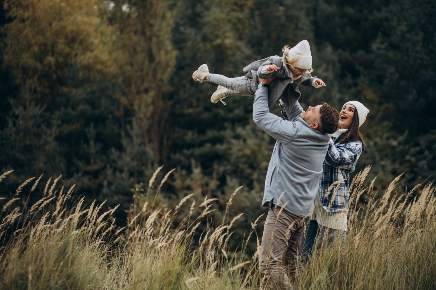 Familia feliz jugando en la naturaleza, ambiente ideal para Tequendama: Corporativa.