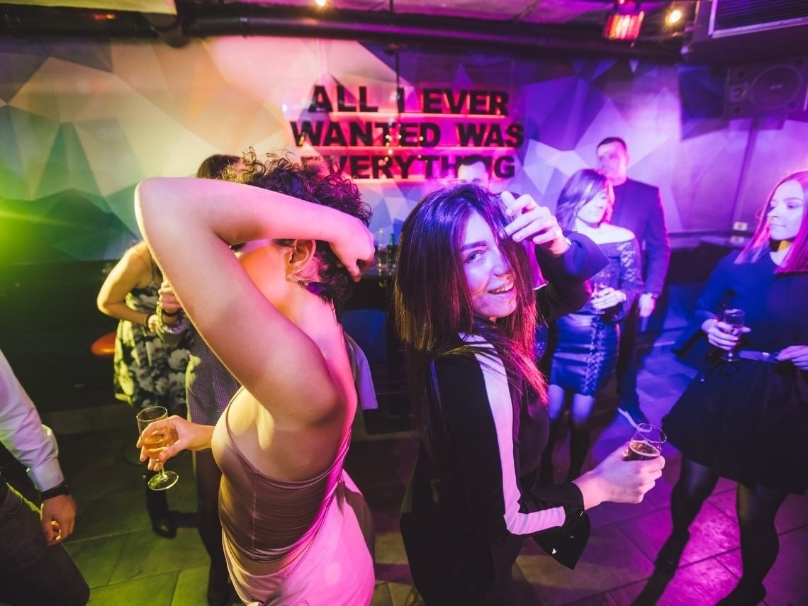 Noche de fiesta en Tequendama: Corporativa con amigos, bailando bajo luces de neón.