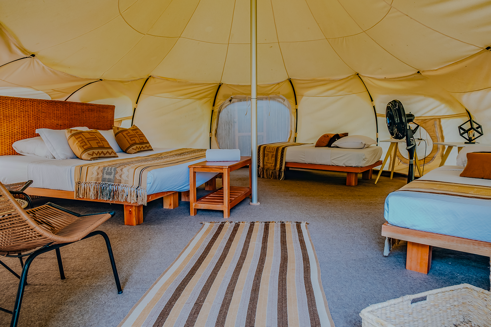 Cozy glamping tent with beds and seating at Ecohabs Tequendama, Tayrona Park.