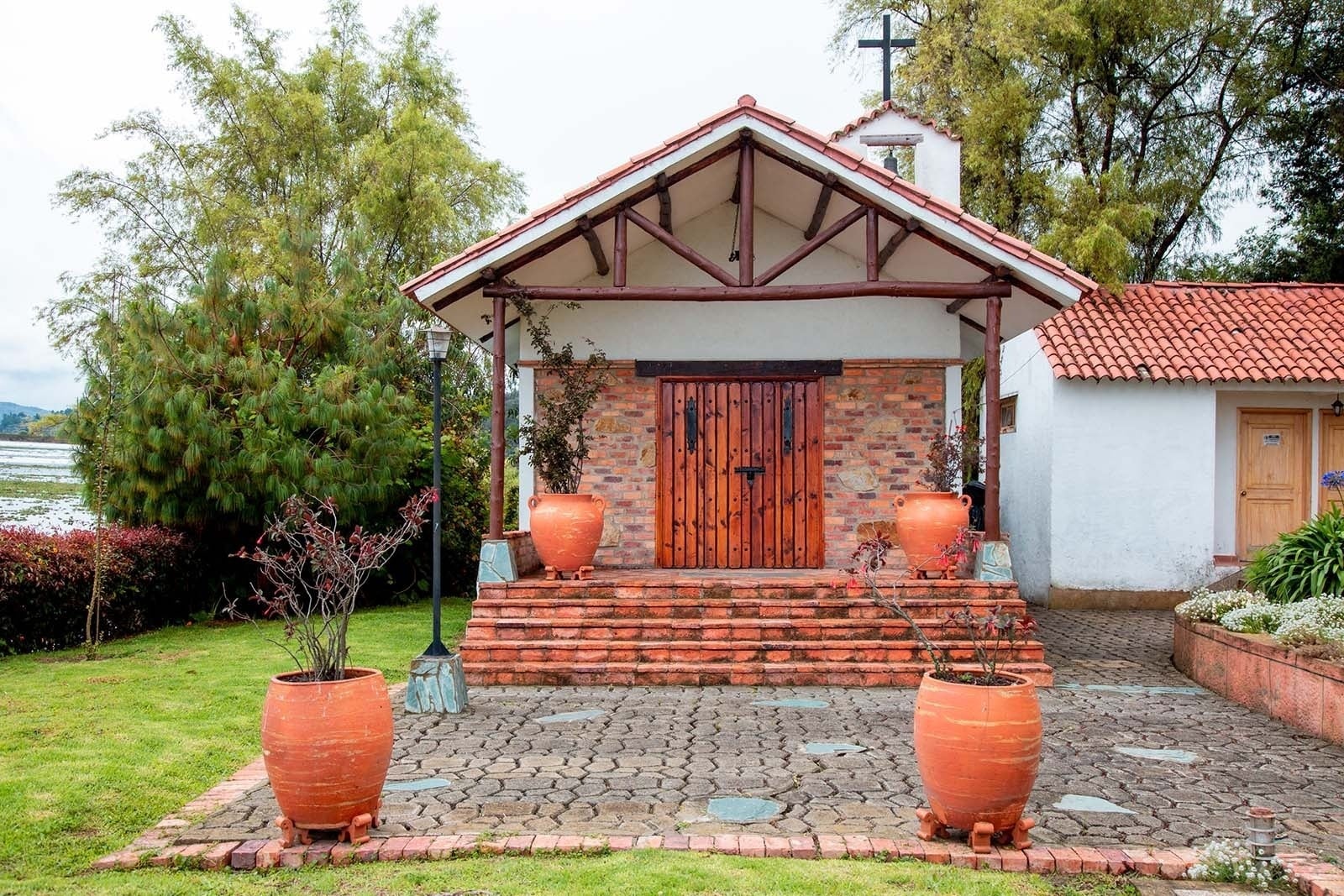 Fachada de Hotel Refugio El Santuario | Hotel en la Laguna de Fúquene, con entrada de ladrillo y campana.