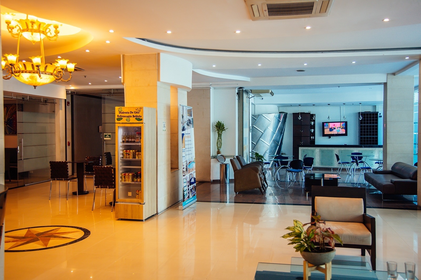 Hotel Plaza Las Américas: Modern lobby with seating, mini-bar, and TV.