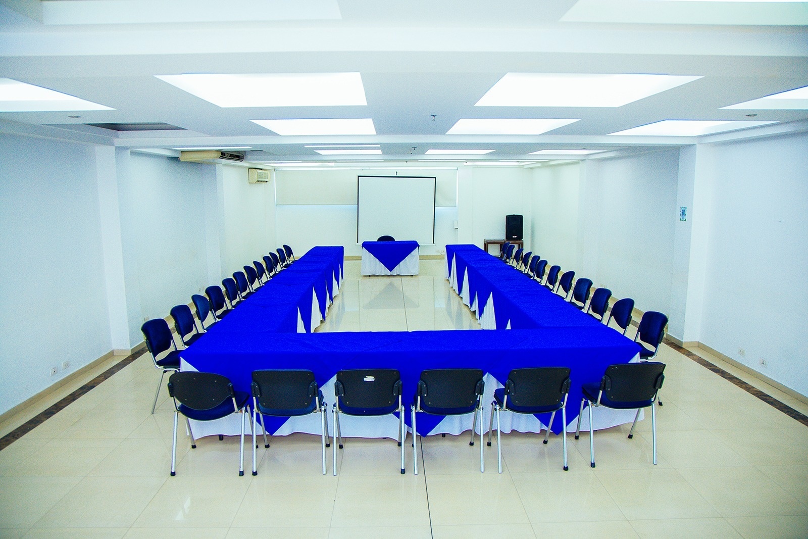 Espacio corporativo Tequendama: sala de conferencias con mesas en forma de U y sillas.