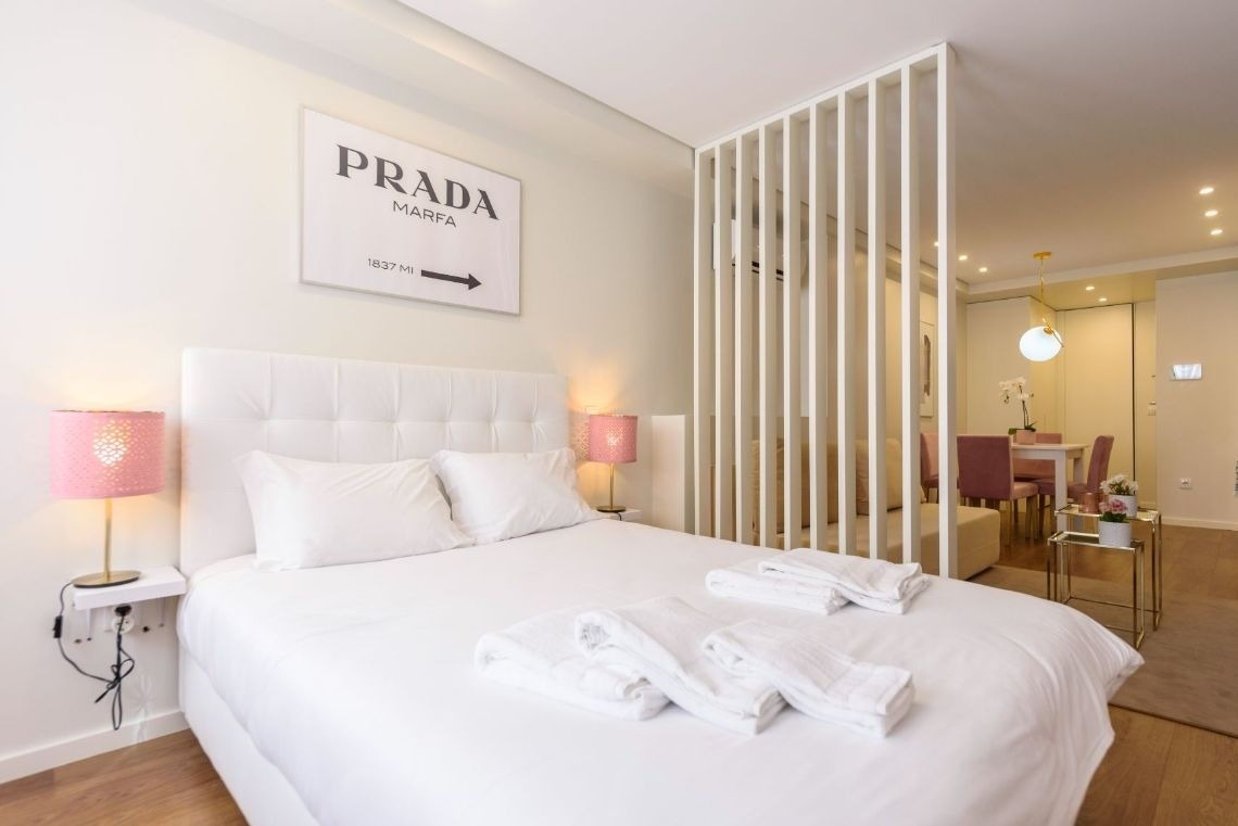 um quarto com uma cama e um pôster de prada