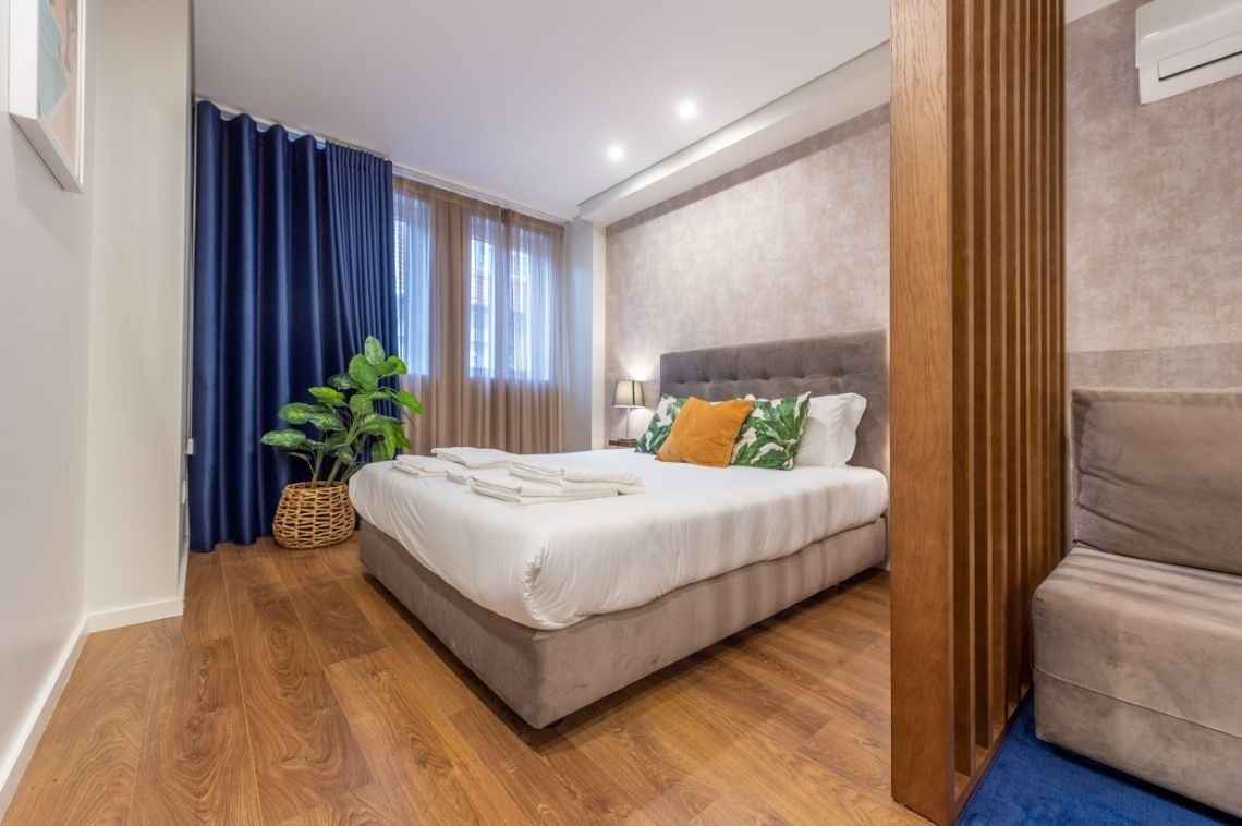 um quarto com cama king size e cortinas azuis