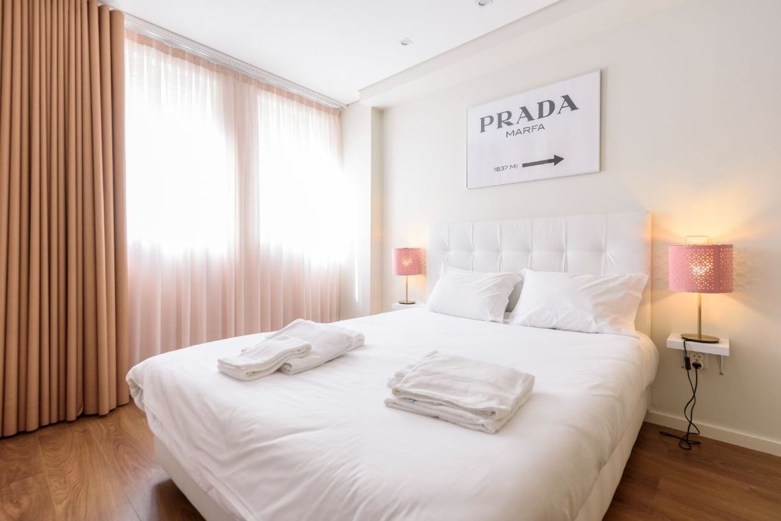 um quarto com uma cama e uma pintura de prada