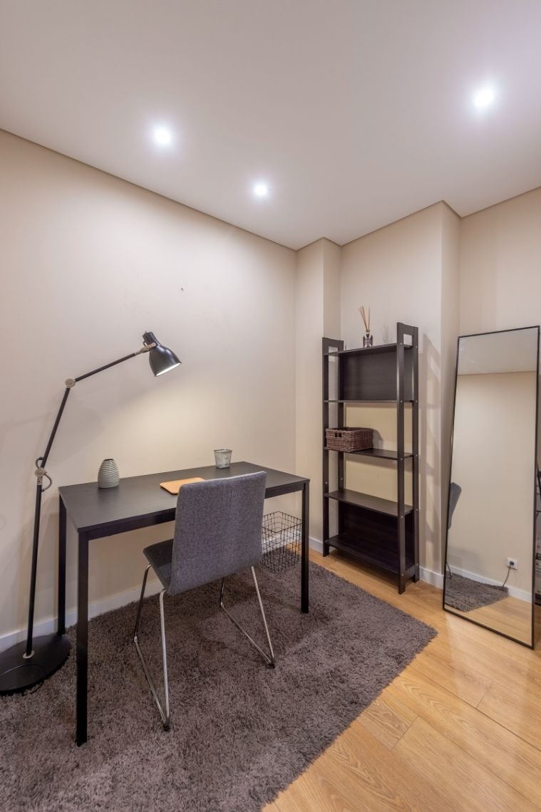 uma sala com uma mesa e uma cadeira e um espelho