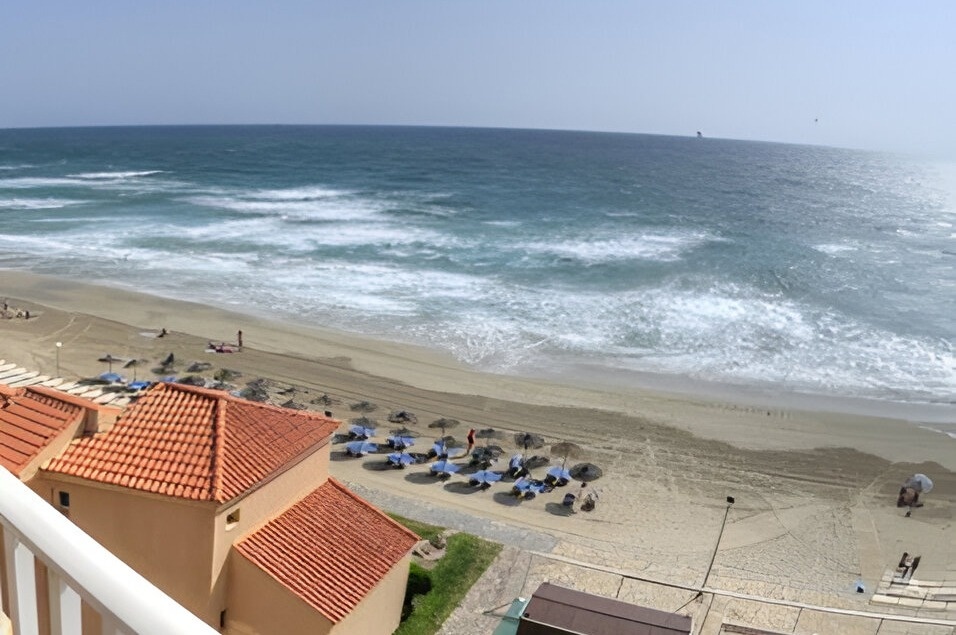 an aerial view of a beach with umbrellas and chairs