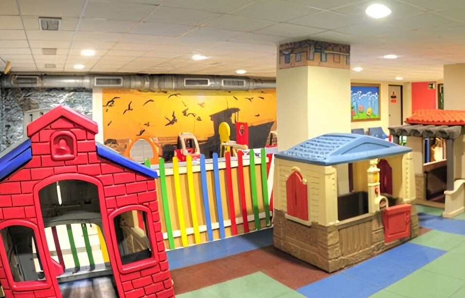 a play area with a red brick house in the middle