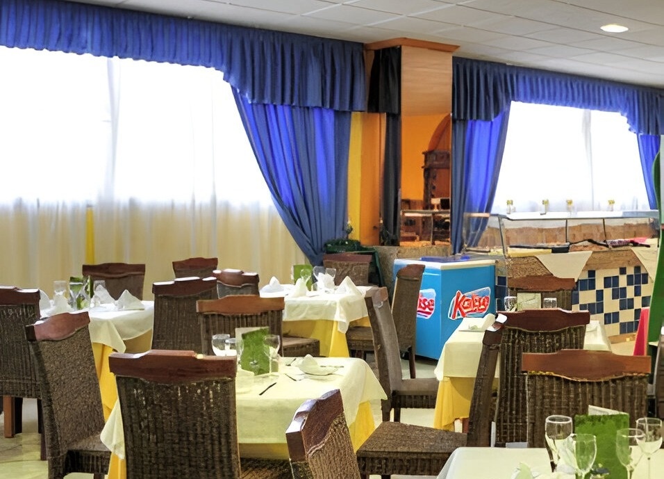 a restaurant with tables and chairs and a kaiser ice cream cooler