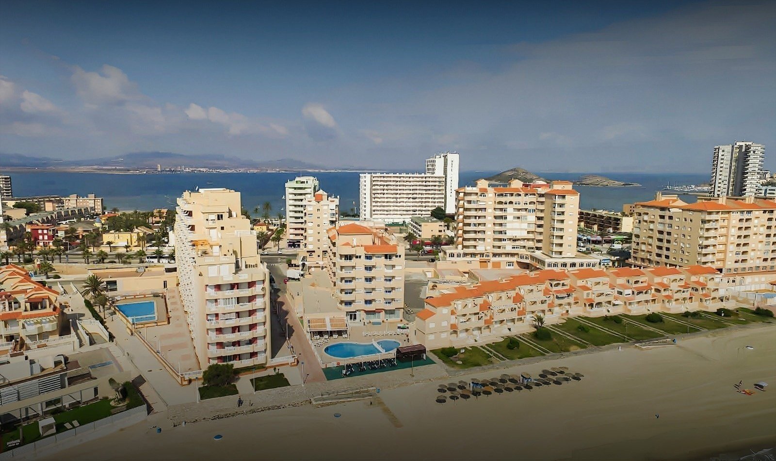 an aerial view of a city with a beach in the foreground