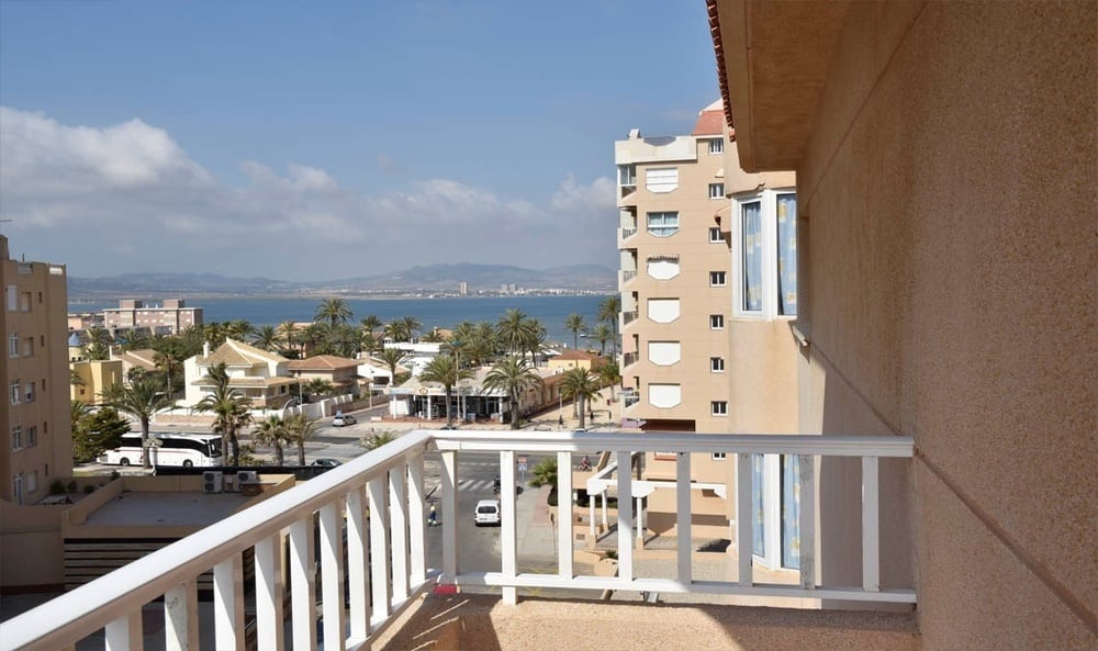 un balcón con una vista al Mar Mediterráneo y un edificio al fondo