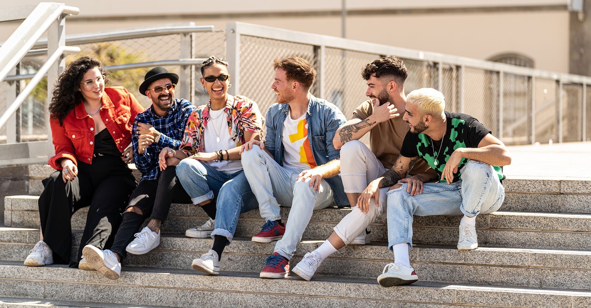 un grupo de jóvenes se sienta en las escaleras y se ríe