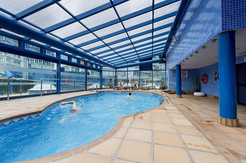 une piscine intérieure avec un toit en verre