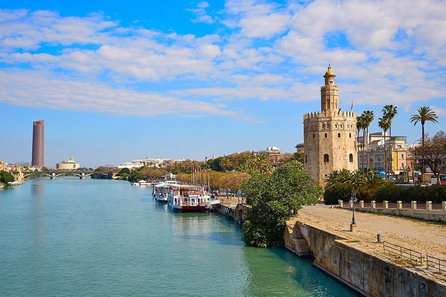 a river with boats and a tower in the background