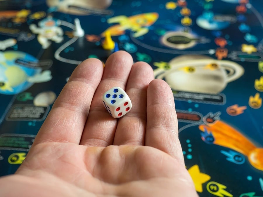 U-Sense: For You Hostel Sevilla: dado en mano sobre tablero espacial.
