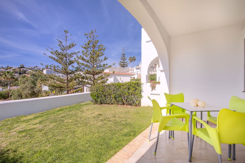 Terraza con sillas y mesa de exterior, vistas a colinas y mar. 