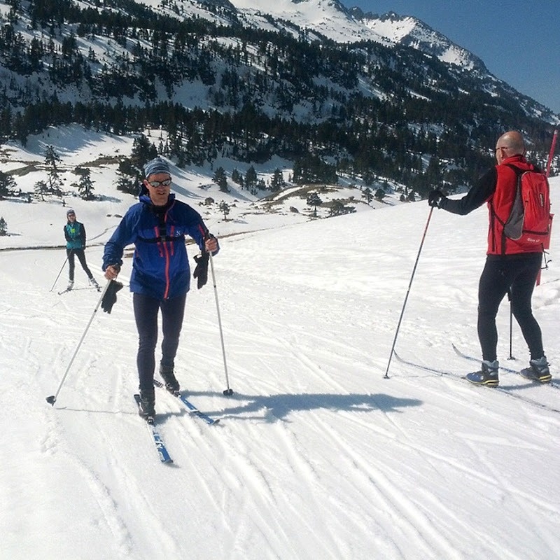 un hombre con una chaqueta azul y una mochila roja está esquiando en la nieve