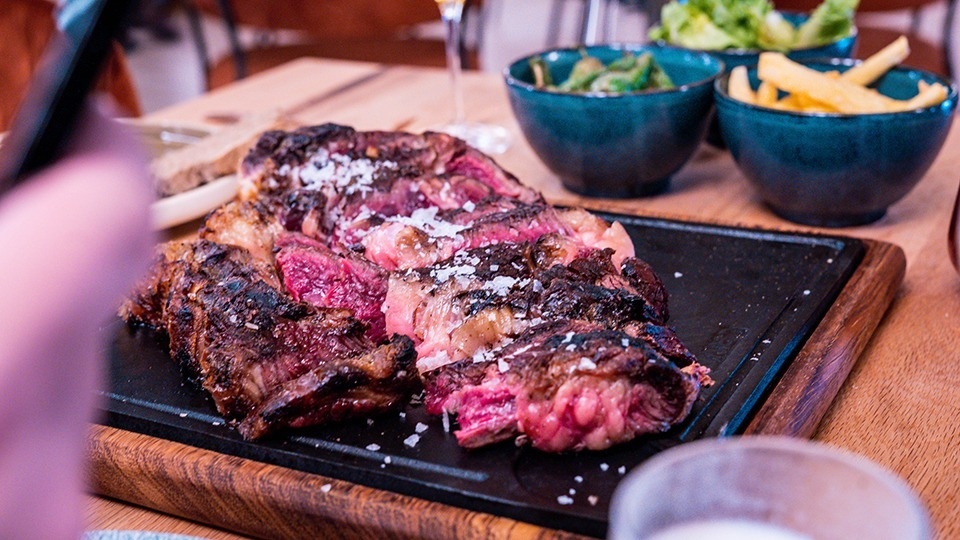 a large piece of meat is sitting on a wooden cutting board