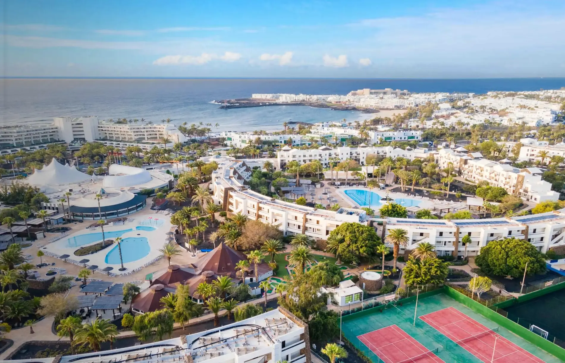 Luftaufnahme von Los Zocos mit Pools, Gärten und Tennisplätzen am Meer