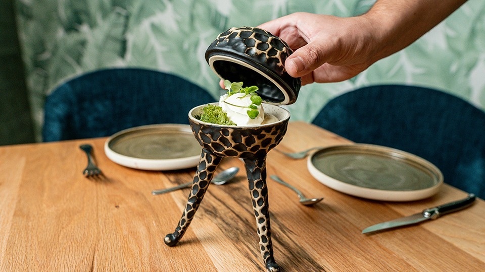 a person is holding a giraffe shaped bowl with ice cream in it