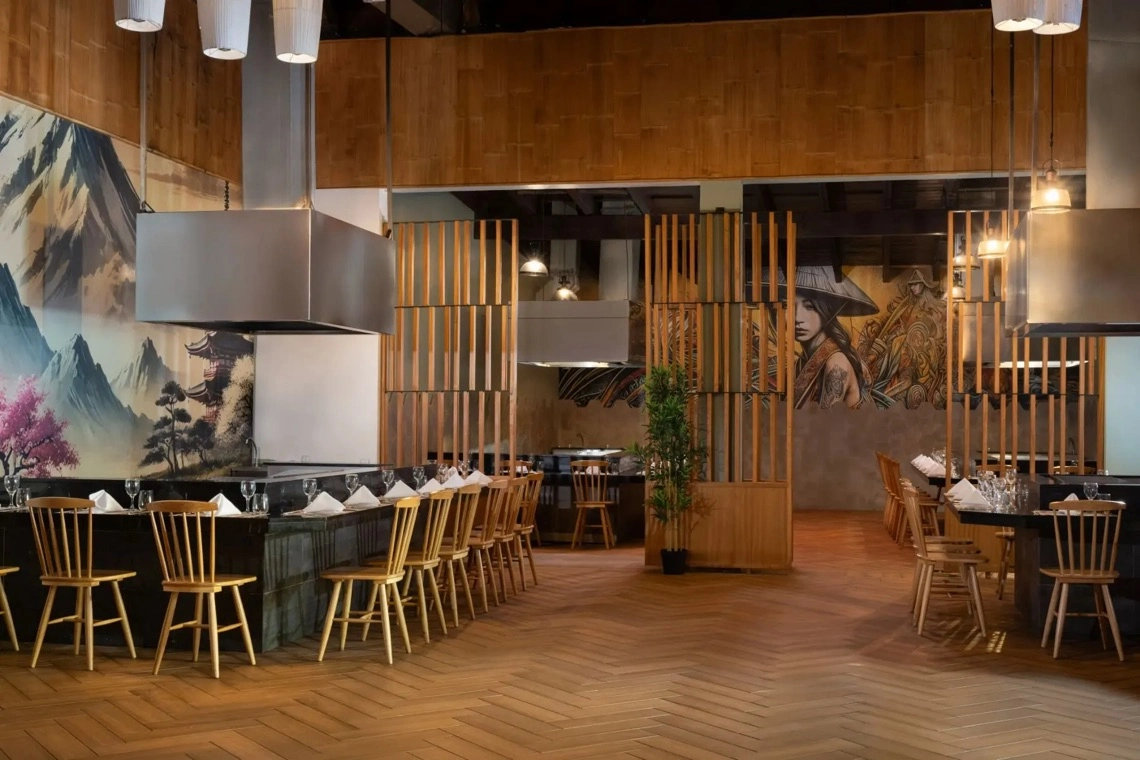 Restaurante con mesas de madera y cocina a la vista