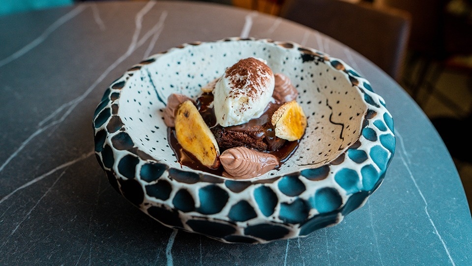 a bowl of food with ice cream and bananas on a table