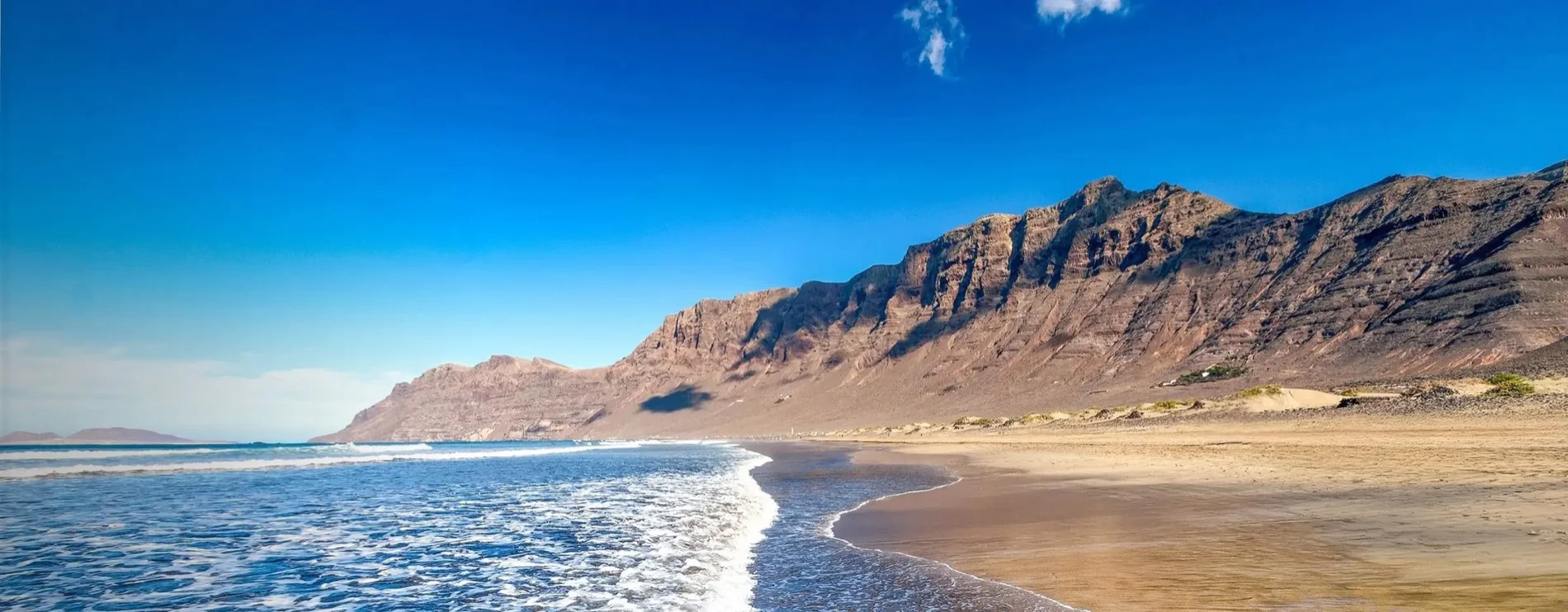 Playa de Famara con sus acantilados y el oleaje en Lanzarote