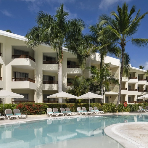 Piscina con tumbonas frente a las habitaciones de Impressive Premium Punta Cana