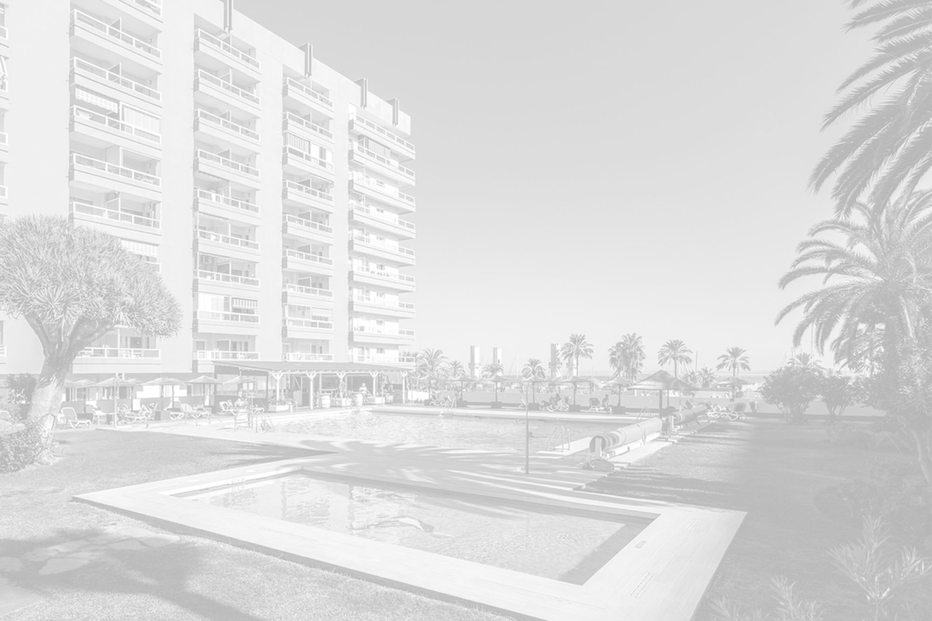 un edificio de apartamentos con una piscina al frente=s1900