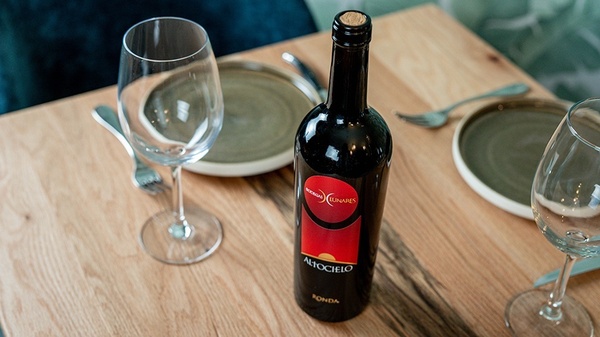 a bottle of altocielo wine sits on a wooden table