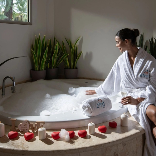 Mujer en albornoz junto a un jacuzzi con velas en el spa de Impressive Premium Punta Cana