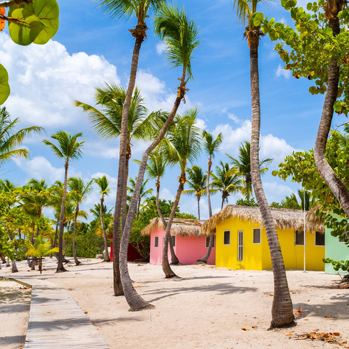 Casitas de colores entre palmeras junto a la playa en Punta Cana
