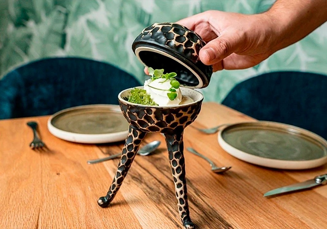 a person is pouring ice cream into a giraffe shaped bowl
