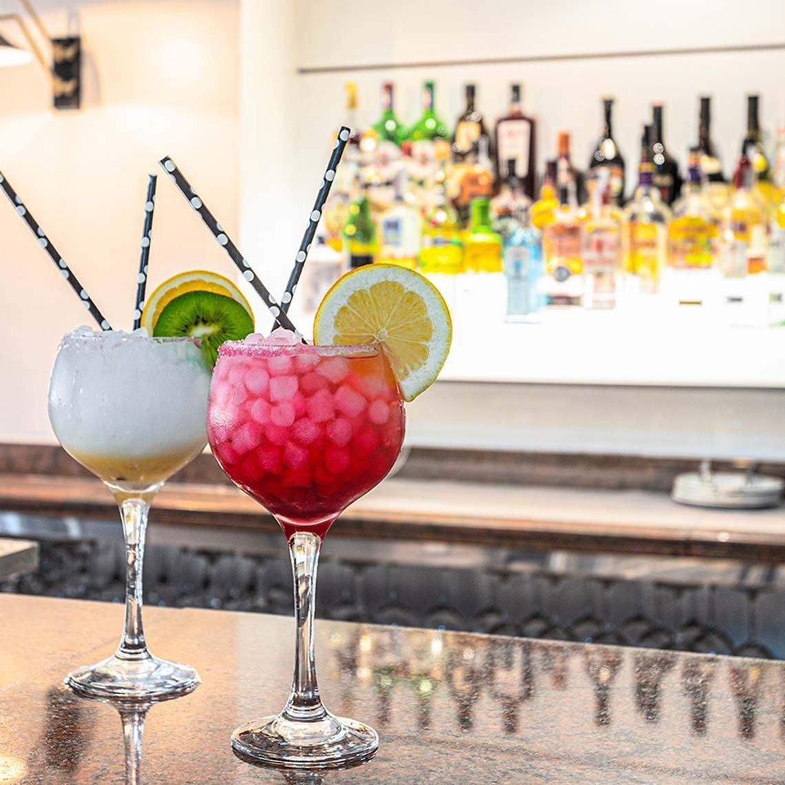 deux cocktails sont assis sur un comptoir de bar
