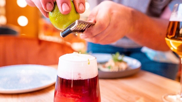 a person is grating a lime into a drink