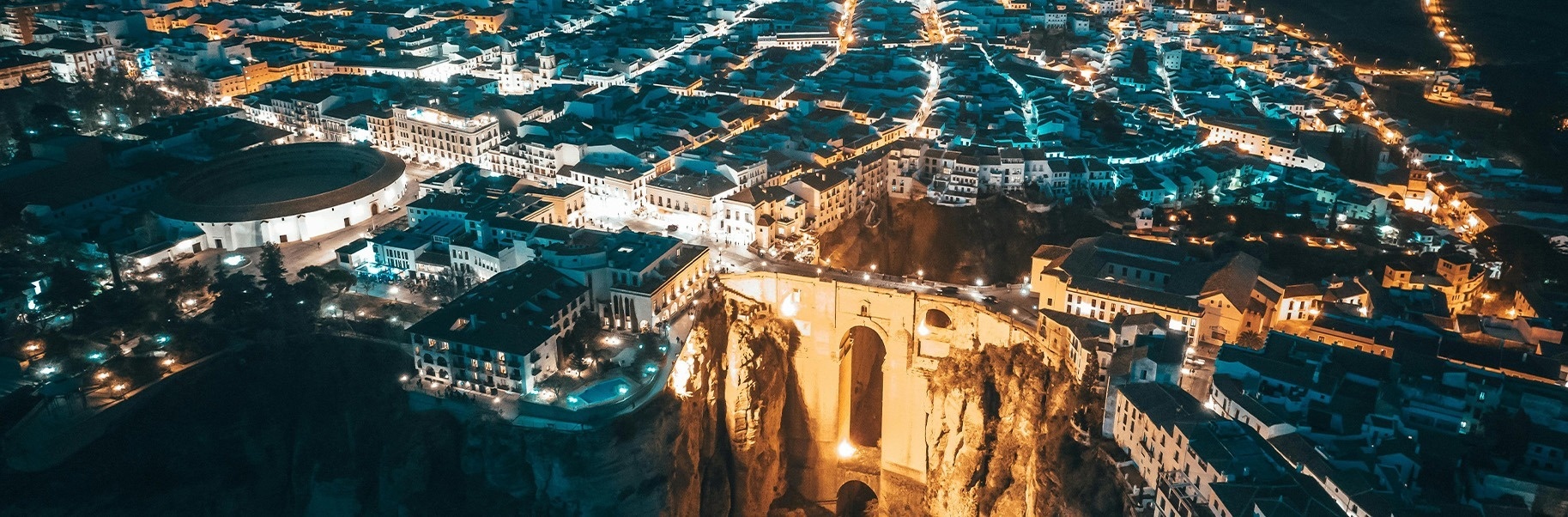 una vista aérea de una ciudad por la noche con un anfiteatro al fondo