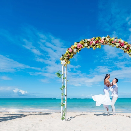 Novios bajo un arco de flores en una playa del Caribe