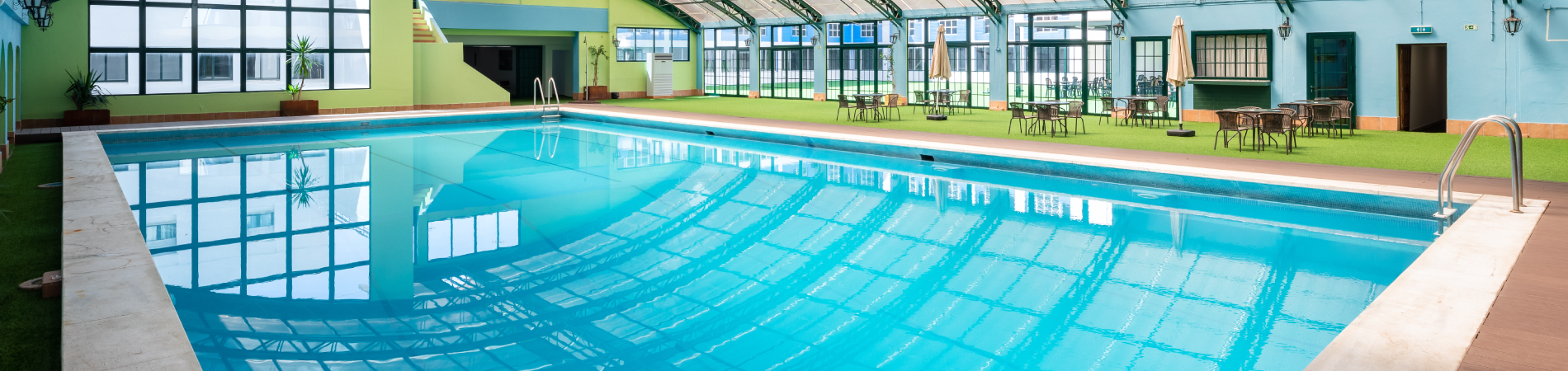 ein großer Swimmingpool in einem Gebäude mit vielen Fenstern