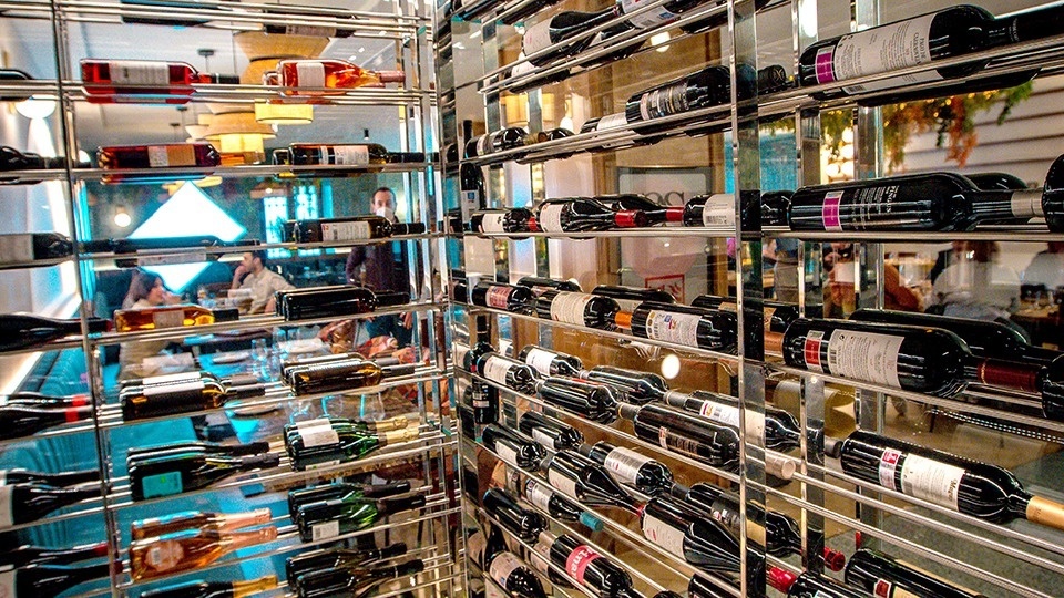 many bottles of wine are lined up in a glass display
